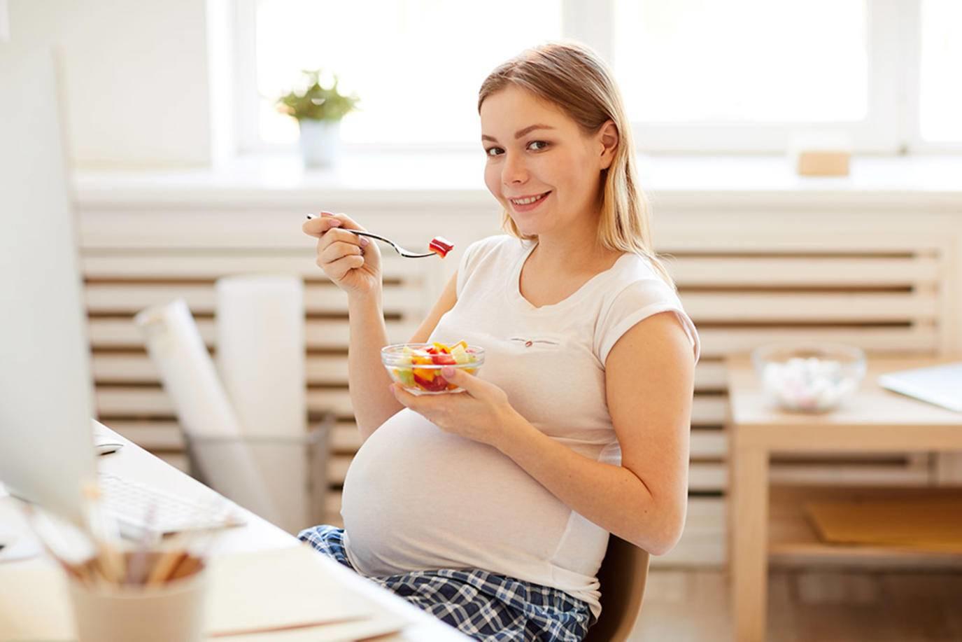 صورة لحامل تتناول وجبة خفيفة صحية
