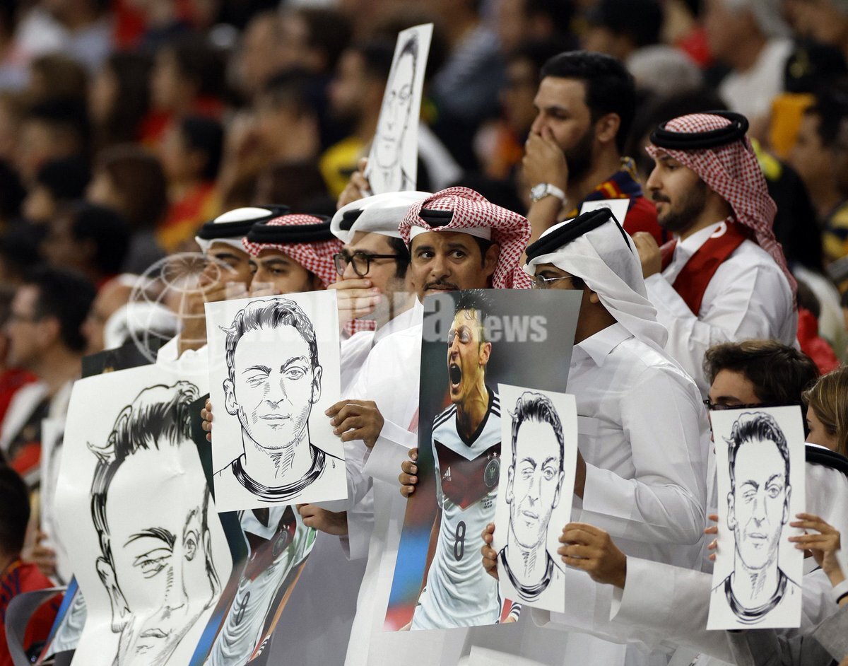 بالصور مشجعين يحملون صورة مسعود أوزيل للرد على عنصرية لاعبي ألمانيا